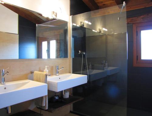 a bathroom with two sinks and a large mirror at Sagardikoetxea I in Oskotz