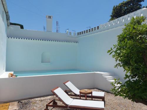 two chairs and a swimming pool on a house at Casa Ancha in Beja