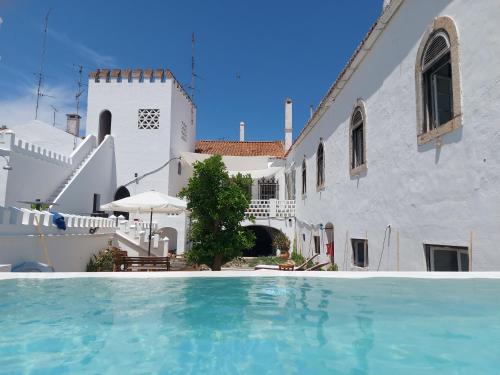 a swimming pool in front of a white building at Casa Ancha in Beja