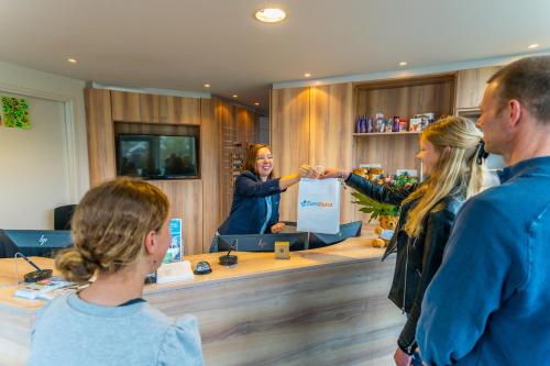 a group of people standing around a counter shaking hands at Europarcs Koningshof in Schoorl