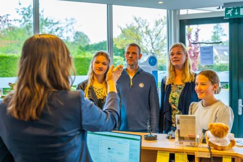 un grupo de personas de pie alrededor de una mesa en una habitación en Europarcs Koningshof, en Schoorl