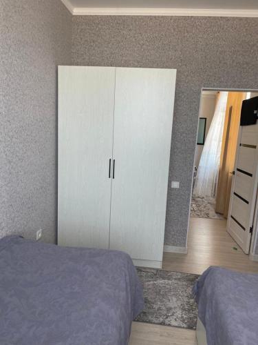 a bedroom with a bed and a white cabinet at Берег-4 in Bosteri