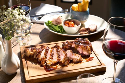 a table with a plate of meat and a plate of food at Royal Marine Hotel in Brora
