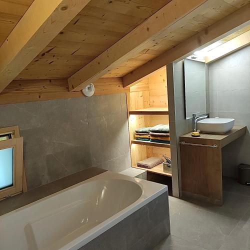 une salle de bain avec une baignoire et un lavabo dans l'établissement Chalet neuf vue panoramique sur le MONT-BLANC, à Combloux