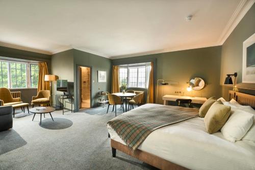 a bedroom with a large bed and a living room at Royal Marine Hotel in Brora
