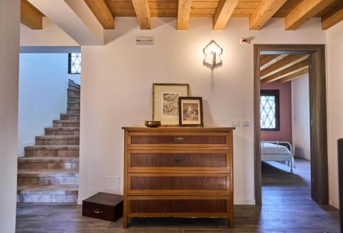 a room with a wooden dresser and stairs at Casale San Pietro in Palmanova