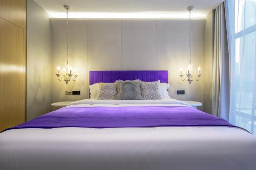 a bedroom with a large bed with purple sheets at Shenzhen ALLIN Space to time in Shenzhen