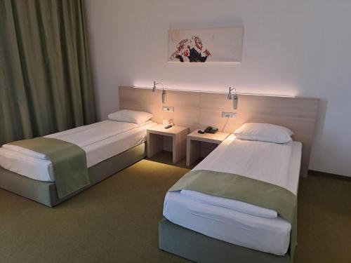 a hotel room with two beds in a room at Hotel Armatti in Braşov
