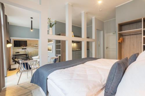 a bedroom with a large white bed and a dining room at acora City Apart Living the City in Hamburg