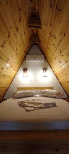 a bed in a room with a wooden ceiling at Valea cu Dor Verde in Pîrscov