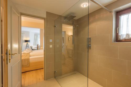 un bagno con doccia con porta in vetro di MANNI das Hotel a Mayrhofen