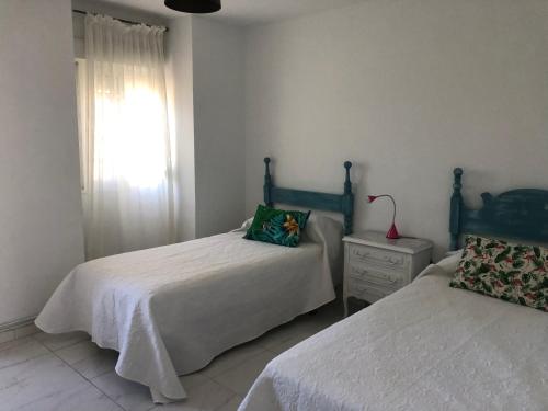 a bedroom with two beds and a window at mar de rosa in Villanueva de Arosa