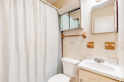 a bathroom with a toilet and a sink and a mirror at AVHC23 Beach Box in Avon