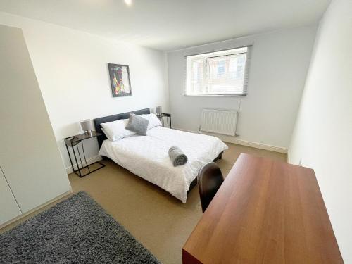 A bed or beds in a room at Travaal - 2 Bed Serviced Apartment Farnborough