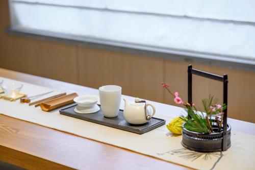 a table with white cups and a tray with flowers at Shenzhen ALLIN Space to time in Shenzhen