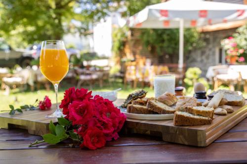 a table with a plate of bread and a glass of orange juice at ΞΕΝΟΔΟΧΕΙΟ ΠΑΠΑΝΑΓΙΩΤΟΥ in Neraïdochóri