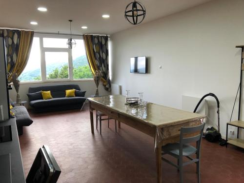 ein Wohnzimmer mit Tisch und Couch in der Unterkunft appartement 10 couchages le lioran bord rando/ski in Le Lioran