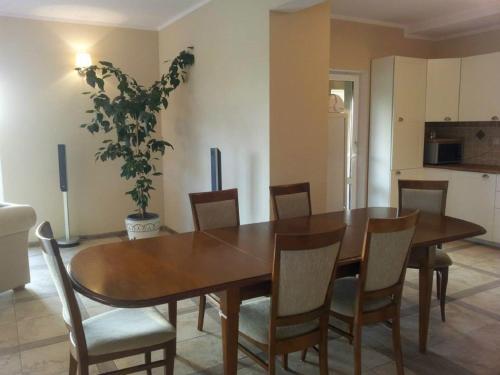 a dining room with a wooden table and chairs at Villa Cheval in Aukštadvaris