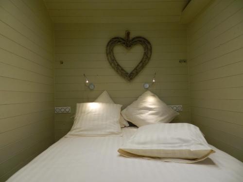 Ce lit se trouve dans un dortoir doté d'un cœur sur le mur. dans l'établissement Gîte Les Marlières, à Esquéhéries