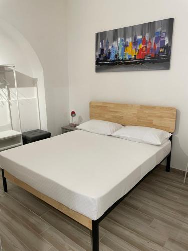 a bed in a bedroom with a white mattress at Corte Capuana in Catania