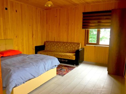 a bedroom with a bed and a couch and a window at ACISU CAFE KONAKLAMA in Trabzon