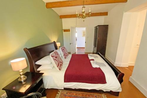 Un dormitorio con una cama con una manta roja. en The Blue House, en Stanford