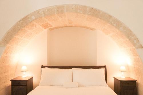 a bedroom with a bed with an arch above it at Masseria Savoia in Ginosa Marina