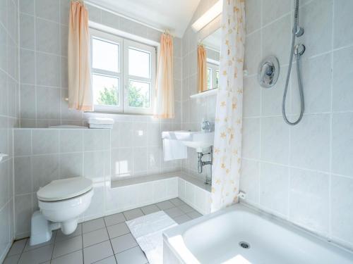 La salle de bains est pourvue d'une baignoire, de toilettes et d'un lavabo. dans l'établissement Feriendorf Rugana - Budget Appartement mit 1 Schlafzimmer A39, à Dranske