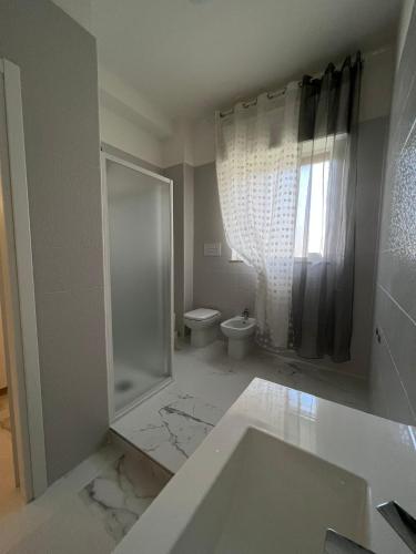 uma casa de banho com um lavatório, um chuveiro e um WC. em Queens Jazz em Foggia