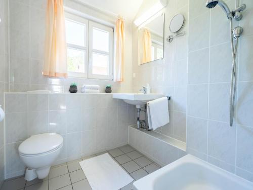ein weißes Badezimmer mit Toilette und Waschbecken in der Unterkunft Feriendorf Rugana - Klassik Appartement mit 1 Schlafzimmer B21 in Dranske