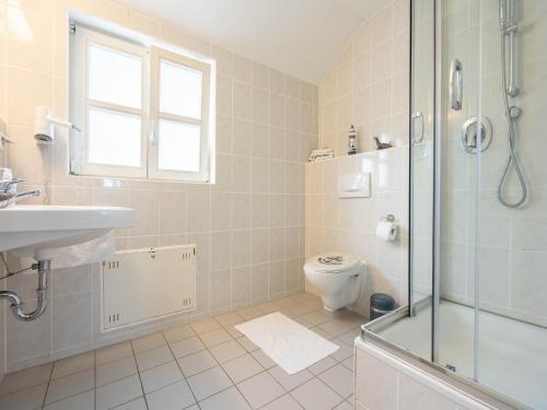 a bathroom with a shower and a toilet and a sink at Feriendorf Rugana - Moderne Komfort Ferienwohnung mit 1 Schlafzimmer C02 in Dranske