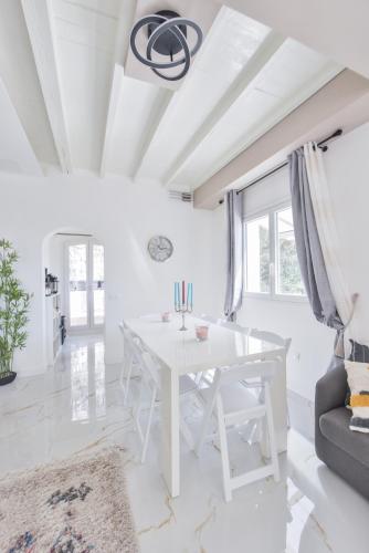 une salle à manger blanche avec une table et des chaises blanches dans l'établissement THE WHITE HOUSE BEAUSOLEIL- Monaco Border, à Beausoleil