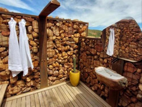 a bathroom with a wooden wall and a wooden deck at Aardts Cabins in De Rust