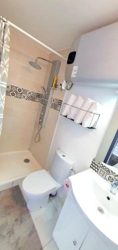 une salle de bain blanche avec des toilettes et un lavabo dans l'établissement MAISON APPARTEMENT TOUT CONFORT À 10mn des plages, à Montpellier