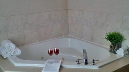 a bathroom with a tub with two glasses of wine at Holiday Inn Express Hotel & Suites Toronto - Markham by IHG in Richmond Hill