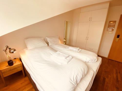 a large white bed in a room with a lamp at Day Dream Vesturgata 17 Reykjavik in Reykjavík