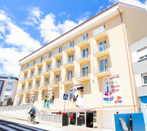 a large yellow building on the side of a street at Hotel Faro de Finisterre in Finisterre