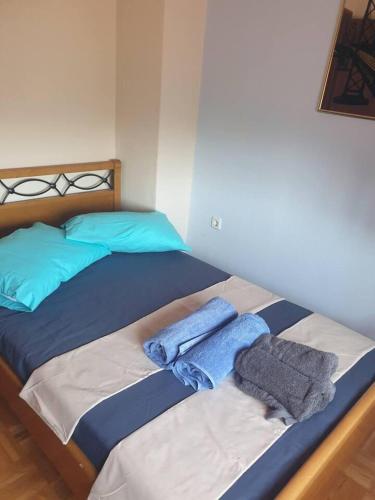 a bed with blue pillows and towels on it at Dream Nikiti xalkidikis in Nikiti