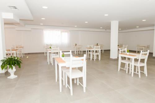 a dining room with white tables and white chairs at Hotel Faro de Finisterre in Finisterre