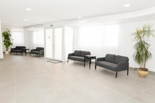 a waiting room with couches and a potted plant at Hotel Faro de Finisterre in Finisterre