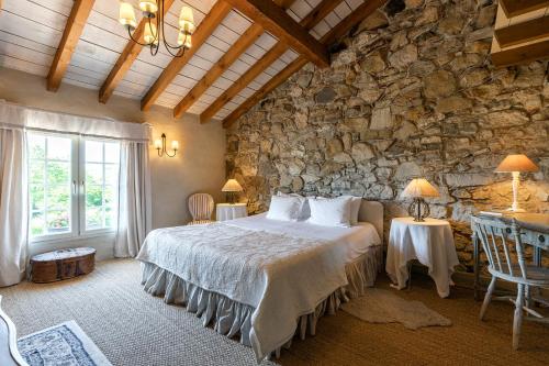 a bedroom with a bed and a stone wall at Domaine de Bassilour in Bidart