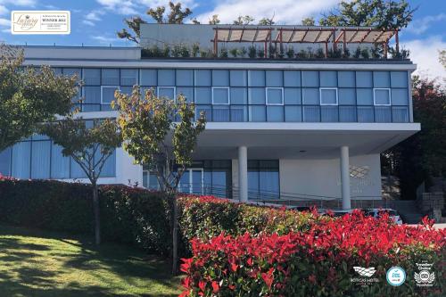a white building with red flowers in front of it at Boticas Hotel Art & SPA in Boticas