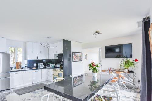 une cuisine avec des armoires blanches et un comptoir noir dans l'établissement BIRDS EYE VILLA Luxury Castle Paranomic Views of Monaco Monte Carlo Hills & Sea, à La Turbie