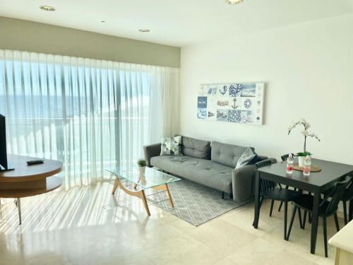 Oceanus apartment hotel في هرتسليا: غرفة معيشة مع أريكة وطاولة