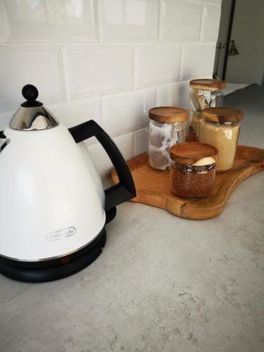 a tea kettle and containers on a wooden cutting board at 10 Jock Meiring Guesthouse Unit 2 in Bloemfontein