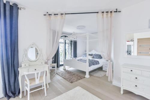 a white bedroom with a bed and a mirror at BIRDS EYE VILLA Luxury Castle Paranomic Views of Monaco Monte Carlo Hills & Sea in La Turbie