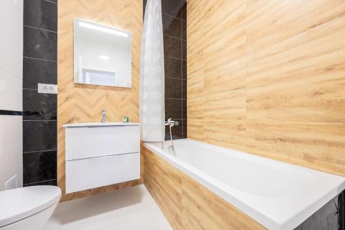 bagno con vasca bianca e lavandino di Brioni Flat a Oradea