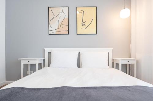 una camera da letto con un letto bianco con due tavoli di Brioni Flat a Oradea
