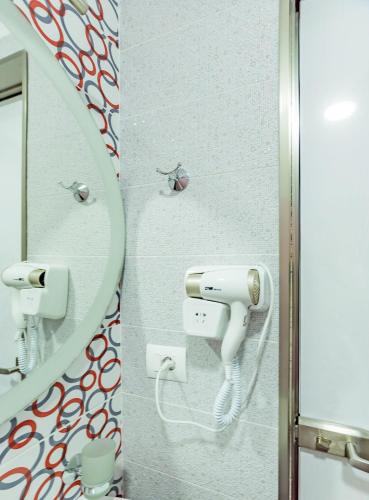 a bathroom with a mirror and a hair dryer at The City Gate Hotel in Sarandë