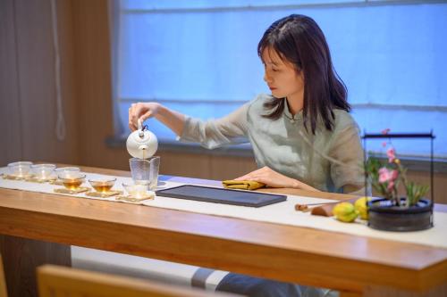 a woman standing at a table pouring a drink at Shenzhen ALLIN Space to time in Shenzhen